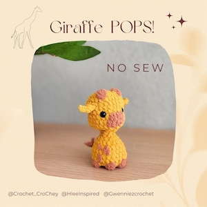 May include: A crocheted giraffe toy with yellow and pink yarn. The toy is sitting on a wooden surface. The text "Giraffe POPS! NO SEW" is visible in the image.