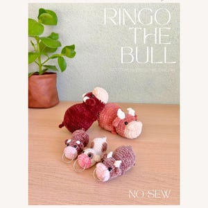 May include: Four crocheted bull amigurumi toys. Two are red, one is brown and white, and one is brown. The larger bulls are lying down, and the smaller bulls are standing. The text "RINGO THE BULL" and "NO SEW" are visible in the image.
