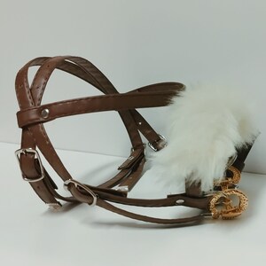 May include: A brown leather dog muzzle with a white fur trim and gold metal accents.