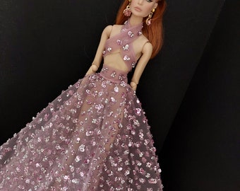 May include: A pink sequined gown with a halter top and a flowing skirt. The gown is adorned with small, iridescent sequins that create a shimmering effect.
