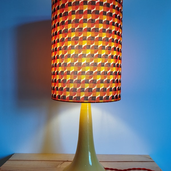 lampe style vintage avec un pied jaune en céramique et un abat jour en coton rouge à motifs pour décorer votre intérieur avec élégance