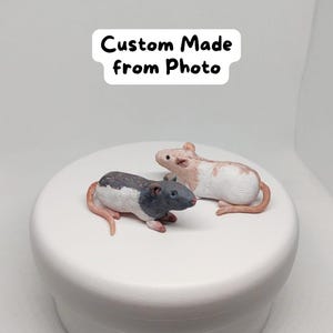 Puede incluir: Dos figuritas de rata hechas a medida, una negra y blanca y otra marrón y blanca, sobre una superficie blanca. El texto "Custom Made from Photo" está en el fondo.