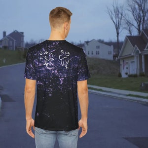 May include: A black t-shirt with a galaxy print and white hand-drawn designs on the back. The designs include a heart, a star, and a few other abstract shapes.