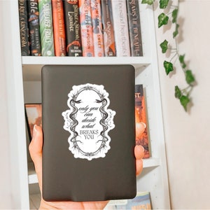 May include: Black and white sticker with a quote that reads "only you can decide what breaks you". The quote is surrounded by a decorative frame with two snakes intertwined.