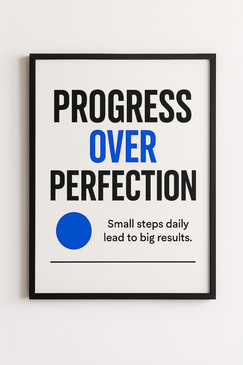 May include: A framed print with the words "PROGRESS OVER PERFECTION" in black and blue. Below the text is a blue circle and the phrase "Small steps daily lead to big results." The frame is black.
