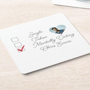 May include: A white coaster with a checklist and a heart-shaped cutout with a photo of Chris Evans. The checklist has three options: Single, Taken, Mentally Dating Chris Evans. The box next to "Mentally Dating Chris Evans" is checked.