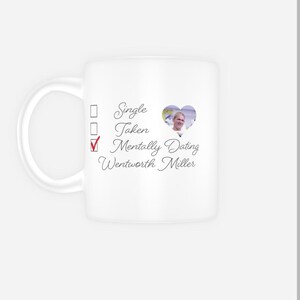 Puede incluir: Taza de cerámica blanca con una lista de verificación que dice "Soltero", "Ocupado", "Mentalmente saliendo con Wentworth Miller" con una marca de verificación junto a "Mentalmente saliendo" y un corazón con una foto de Wentworth Miller dentro.