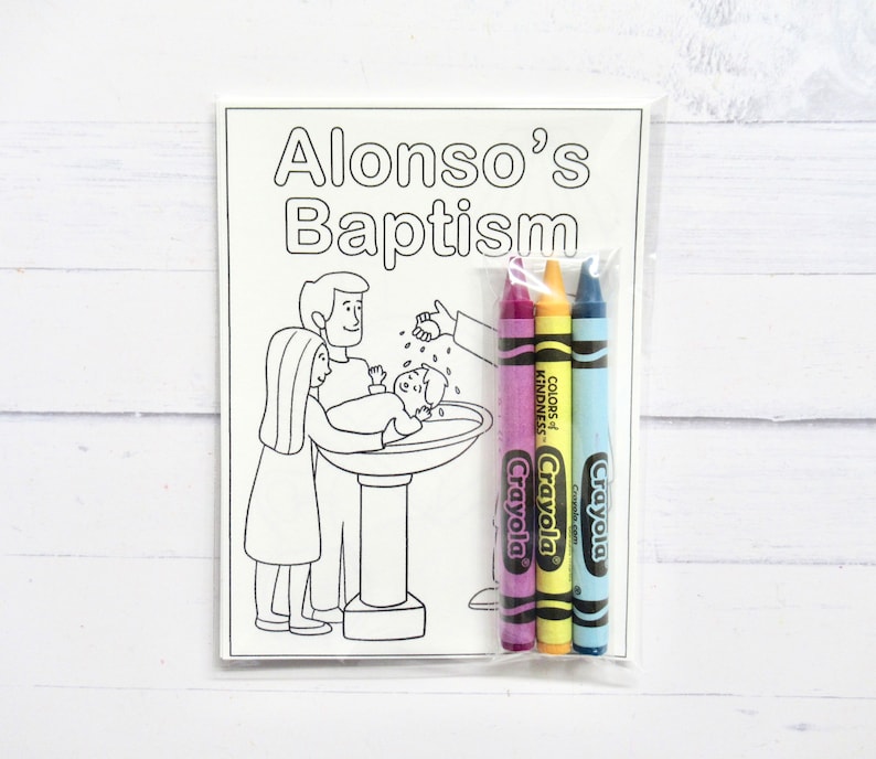 May include: A black and white coloring page with a scene of a baptism. The page is titled "Alonso's Baptism". The image shows a baby being baptized by a person pouring water from a pitcher. There are three crayons included in a plastic bag.