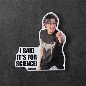 May include: A white sticker with a cutout of a person pointing, wearing a black shirt with a decorative design. The sticker has the text "I SAID IT'S FOR SCIENCE!" and "CultRacha" in black font.