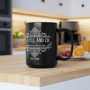 May include: Black ceramic coffee mug with a white design that reads "A.Z. Fell and Co. Antiquarian and Unusual Books Est. 1800".