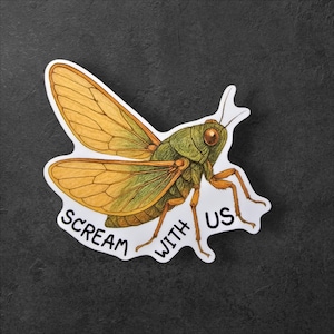 Puede incluir: Una pegatina con una ilustración detallada de un saltamontes con alas y cuerpo amarillos y verdes. El texto blanco "SCREAM WITH US" sigue la forma de la pegatina. La pegatina está sobre un fondo gris oscuro.