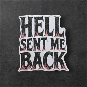 以下が含まれることがあります： HELL SENT ME BACKという文字が太くかすれた黒いフォントで描かれたダイカットステッカー。文字はテクスチャパターンで塗りつぶされ、白い背景に対して淡いピンクとオレンジの炎のデザインで縁取られています。