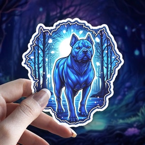 Puede incluir: Una pegatina azul y blanca con un perro pit bull azul de pie en un entorno de bosque. El perro está en una pose mística con una luz brillante detrás de él.