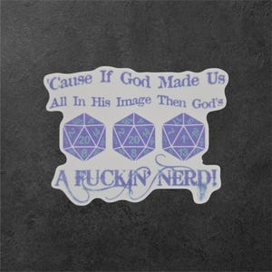 Puede incluir: Una pegatina con el texto "Cause If God Made Us All In His Image Then God's A FUCKIN NERD!" en morado claro. El diseño incluye tres dados morados de veinte caras. La pegatina está sobre un fondo gris oscuro.
