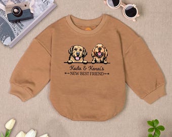Puede incluir: Una sudadera marrón de manga larga con un gráfico de dos golden retrievers y el texto "Koda & Kenai's New Best Friend".