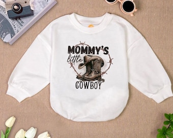 May include: White long-sleeved shirt with a graphic of cowboy boots and the text "Mommy's little cowboy".