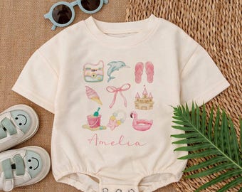 May include: A white short-sleeved bodysuit with a pink and blue watercolor design of summer vacation items. The design includes a beach bag, flip flops, a seashell, a dolphin, a sandcastle, a bucket and shovel, a flamingo float, a bow, and a flower crown. The text "Amelia" is printed in pink below the design.