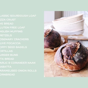 May include: Two freshly baked sourdough loaves with a dark, crusty exterior sit on a wooden cutting board. The image also shows a list of baked goods, including pizza crust, rye bread, and English muffins. A bread lame and proofing baskets are also visible.