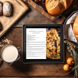 May include: A digital tablet displaying a recipe for Rosemary & Garlic Focaccia. The recipe includes ingredients and instructions. The tablet is surrounded by various food items, including bread, rolls, and herbs.