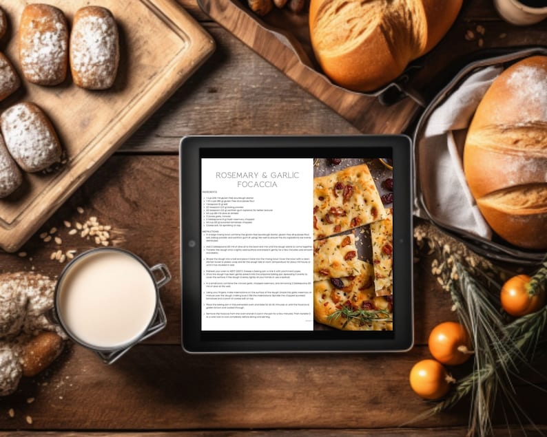 May include: A digital tablet displaying a recipe for Rosemary & Garlic Focaccia. The recipe includes ingredients and instructions. The tablet is surrounded by various food items, including bread, rolls, and herbs.
