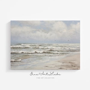 May include: A rectangular canvas print featuring an oil painting of a coastal scene with gentle ocean waves rolling onto a sandy beach under a cloudy sky. The text "Eine Art Liebe FINE ART COLLECTION" is printed in black below the artwork.