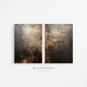 May include: Two rectangular wall art canvases featuring a textured, abstract composition in shades of black, dark brown, and metallic gold. The surface displays layered paint strokes and visible impasto texture. Below the art is the text "Eine Art Liebe FINE ART COLLECTION".