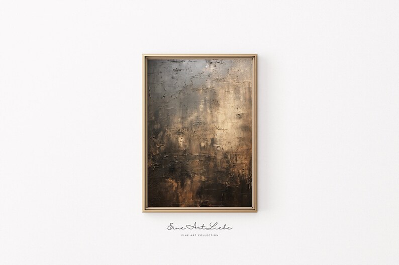 May include: Abstract painting in shades of brown, gray, and gold with a textured surface. The painting is framed in a gold frame and is hanging on a white wall. The text "Eine Art Liebe Fine Art Collection" is printed below the frame.