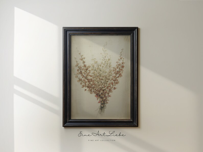 May include: A framed print of a bouquet of dried flowers in shades of brown, pink, and white. The flowers are arranged in a vase and are set against a white background. The frame is black and has a simple design.