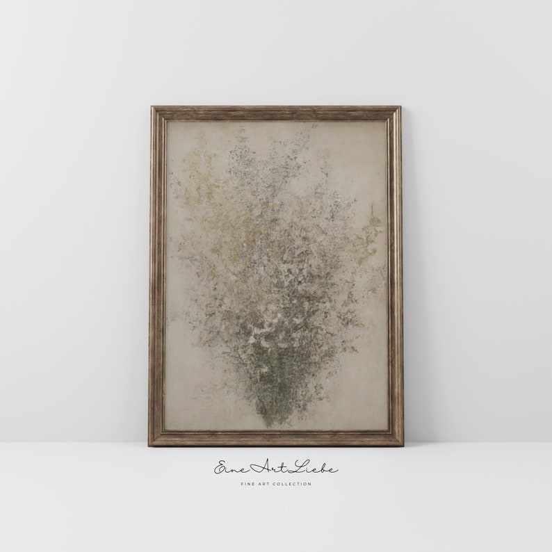 May include: A framed abstract painting with a textured, speckled design in shades of beige, brown, and green. The frame is a simple, gold-toned metal.