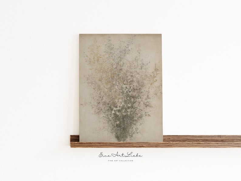 May include: Abstract art print featuring a textured background with a cluster of light brown and green shapes resembling a bouquet of flowers. The print is framed and displayed on a wooden shelf. The text "Eine Art Liebe" is printed below the image.