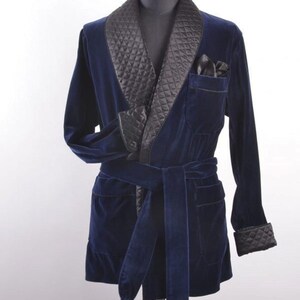 May include: A navy blue velvet dressing gown with a quilted black satin shawl collar, cuffs, and pocket trim. It has a matching belt and pocket square. A classic piece of loungewear.