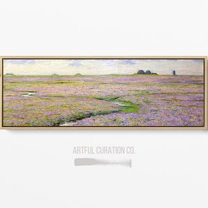 May include: A landscape painting of a field of purple flowers with a small stream. In the distance are a few buildings and a windmill. The artwork is in a rectangular, light-colored wooden frame. The text "ARTFUL CURATION CO." is visible.