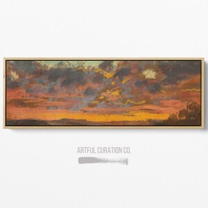 Puede incluir: Una pintura de paisaje rectangular en un marco de madera clara que muestra un atardecer dram&aacute;tico con bandas horizontales de nubes de color naranja oscuro, marr&oacute;n y azul apagado. El texto ARTFUL CURATION CO. aparece en gris debajo.