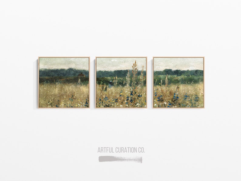 Pu&ograve; includere: Tre dipinti di paesaggio incorniciati con una tavolozza di colori tenui che raffigurano un campo di fiori selvatici e una linea di foresta lontana. I dipinti sono disposti in fila su una parete bianca.