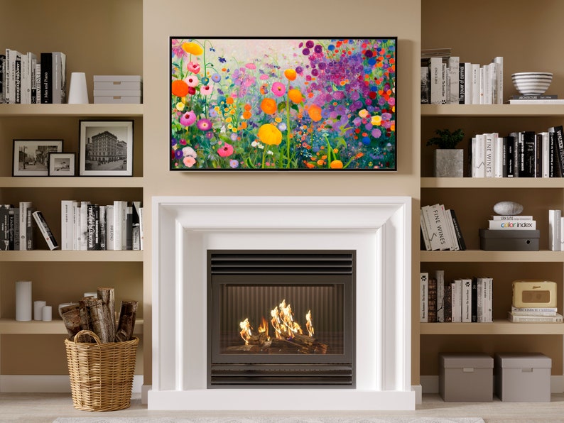 May include: A white fireplace with a black metal grate and a fire burning inside. The fireplace is surrounded by white trim and is set against a beige wall. There are bookshelves on either side of the fireplace, filled with books and decorative items.