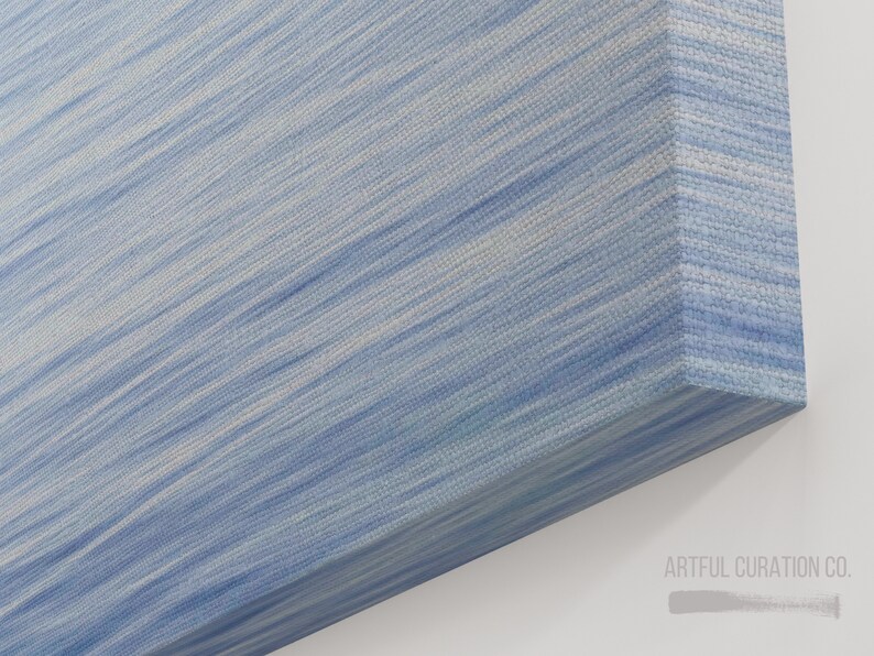 May include: A canvas art piece with a textured surface. The artwork features a diagonal pattern of light blue and white brushstrokes, creating a flowing, abstract design. The corner of the canvas is visible, showing the wrapped edges.