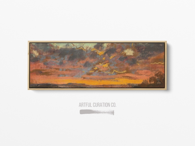 Puede incluir: Una pintura de paisaje rectangular en un marco de madera clara que muestra un atardecer dram&aacute;tico con bandas horizontales de nubes de color naranja oscuro, marr&oacute;n y azul apagado. El texto ARTFUL CURATION CO. aparece en gris debajo.
