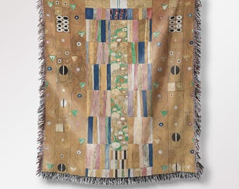 May include: A woven throw blanket featuring a colorful geometric pattern inspired by the artwork "The Kiss" by Gustav Klimt. The blanket has a fringed edge and is made of soft, comfortable fabric.