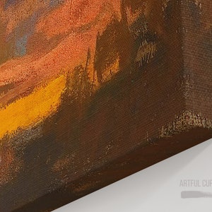 Puede incluir: Un lienzo impreso con una pintura de paisaje texturizada en tonos vibrantes de naranja, amarillo y marr&oacute;n oscuro. La obra muestra una escena de atardecer o amanecer con pinceladas visibles. El texto ARTFUL CURATION CO. est&aacute; impreso en la esquina.