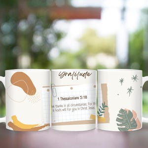 May include: Set of three white ceramic mugs with abstract designs. The mugs feature a quote from the Bible, 1 Thessalonians 5:18, "Give thanks in all circumstances; for this is God's will for you in Christ Jesus."
