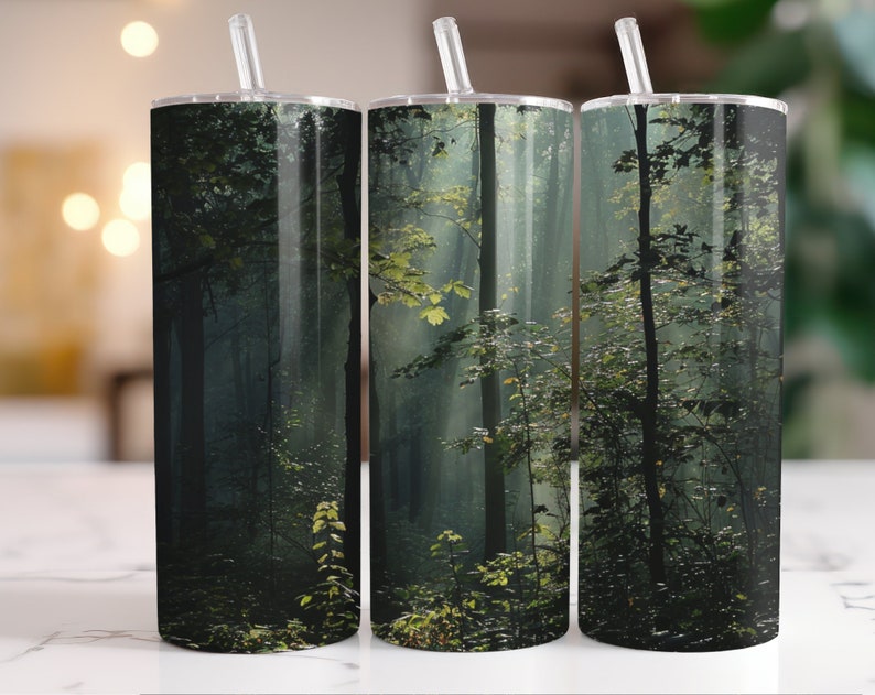 May include: Three stainless steel tumblers with a misty forest scene printed on them. The scene features tall trees and green foliage.