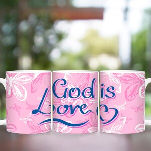 May include: Three pink ceramic mugs with a white floral pattern. The middle mug has the text "God is Love" in blue and pink lettering.
