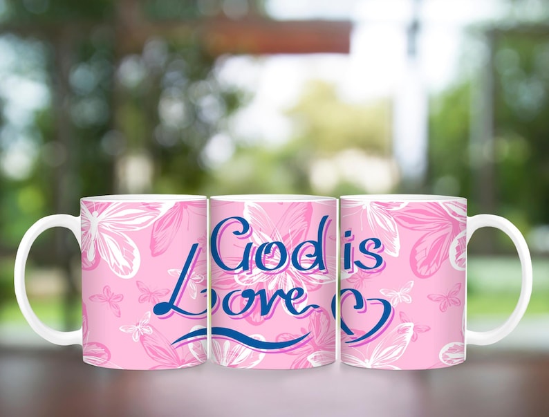 May include: Three pink ceramic mugs with a white floral pattern. The middle mug has the text "God is Love" in blue and pink lettering.