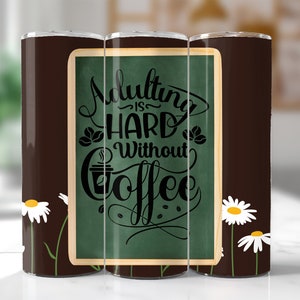 Pu&ograve; includere: Un bicchiere marrone e verde con un design di margherita bianca. Il bicchiere ha un design in stile lavagna con il testo "Adulting is hard without coffee".