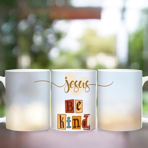 May include: Three white ceramic mugs with a blurred background. The middle mug has the words "Jesus Be Kind" in colorful block letters.
