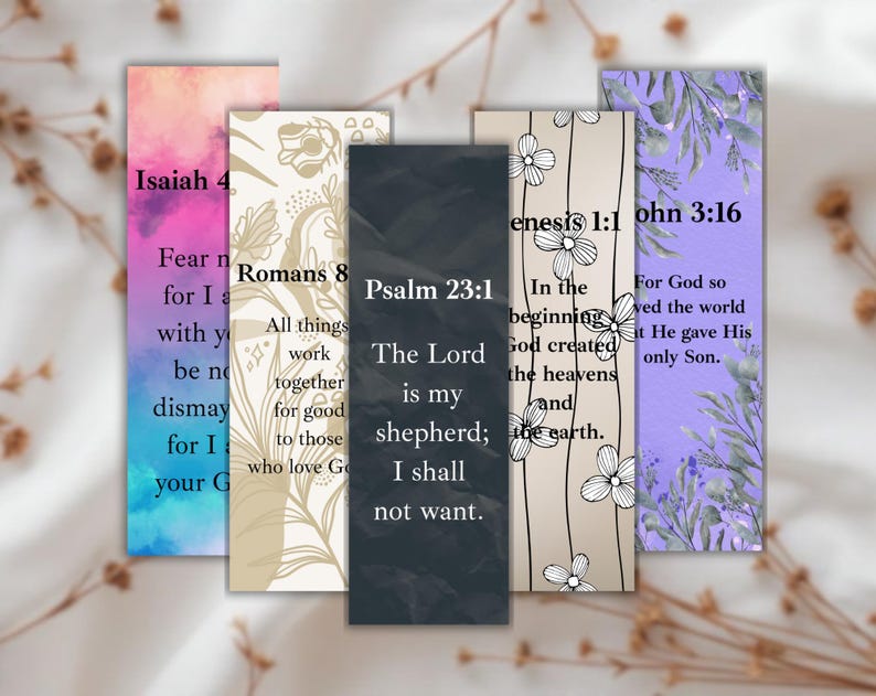 May include: A collection of five rectangular bookmarks with inspirational quotes from the Bible. Each bookmark features a different design, including floral patterns and watercolor backgrounds in shades of pink, purple, and beige. The text includes verses from Isaiah, Romans, Psalm, Genesis, and John.