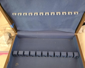 Estuche para cubiertos azul con forro de imitación madera, capacidad para 12 servicios.