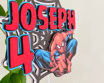 May include: A red, black, and blue 3D cake topper featuring a Spiderman character, a web, and the name "JOSEPH" and the number "4".