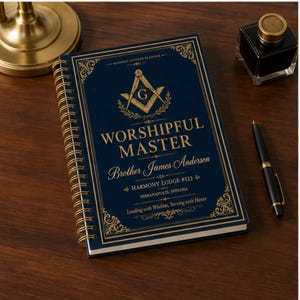 Könnte beinhalten: Ein dunkelblauer, spiralgebundener Masonic Officer Planner mit goldenen Akzenten. Der Einband zeigt ein Winkel-und-Zirkel-Emblem mit einem G sowie den Text Worshipful Master, Brother James Anderson, Harmony Lodge #123, Indianapolis, Indiana.