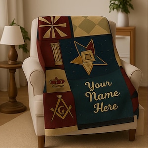 May include: A decorative throw blanket draped over a white armchair. The blanket features a patchwork design with Masonic symbols in burgundy, gold, and teal. The text "Your Name Here" is embroidered on the blanket.
